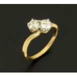 An 18 ct two tone gold crossover set ring, set with diamonds weighing +/- .