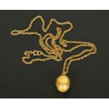 A 9 ct gold fine link chain, with egg shaped locket, gross weight 15.5 grams (see illustration).