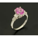 An 18 ct white gold oval pink sapphire and baguette diamond shoulder ring, sapphire weight +/- 2.