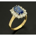 An 18 ct yellow gold emerald cut sapphire and round brilliant cut diamond cluster ring,