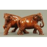 A pair of carved wood Indian elephants, early 20th century, each with inset glass eyes. Height 18.