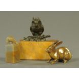 A bronze owl paperweight, raised on a yellow variegated marble stand, length 11 cm,