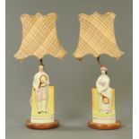 A pair of Staffordshire figures of tennis players, converted to lamps and with tartan shades.