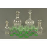 Four antique cut glass decanters and stoppers, and ten Edwardian green tinted wine glasses.