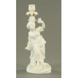 A John Bevington porcelain candlestick, modelled as a female against a leafy trunk,