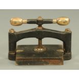 A Victorian cast iron and brass table top book press. Width 42 cm (see illustration).