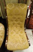 A Victorian walnut framed button upholstered nursing chair with scroll design raised on scroll feet