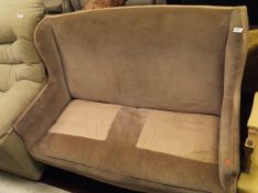 An Edwardian two seat sofa in fawn upholstery with square section tapering legs to brown china