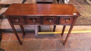 A mahogany side table, the plain top above four drawers with knob handles and inscribed "Ginger",