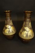 A pair of Moser of Karlsbad amber glass baluster shaped vases gilt decorated in relief with