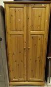 A suite of pine bedroom furniture to include a two door wardrobe, double bed frame,