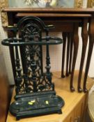 A green painted iron umbrella stand and a mahogany nest of three coffee tables with red leather