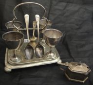 A George V silver egg cruet set on stand comprising four cups and three spoons (by Atkin Brothers,