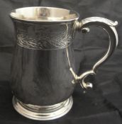 A mid 18th Century George II silver mug of baluster form with C scroll handle,