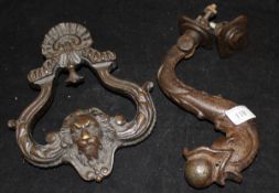 A cast iron "Dolphin and ball" door knocker and a bronze lion mask door knocker