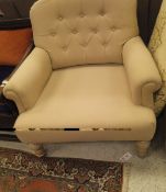 A beige button back wide seat single armchair