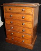 A circa 1900 walnut miniature collectors chest of six drawers with turned knob handles raised on a