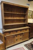A 19th Century pine dresser with four open shelves above a base consisting of a bank of three short