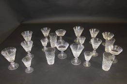 A suite of Waterford cut glasses comprising wines, liqueurs, etc, a blown glass rolling pin,