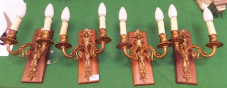 A set of four gilt twin branch wall light fittings