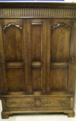 A 20th Century oak two door wardrobe with dentil carved corners above two panelled doors above two
