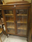 An oak display cabinet with leaded glazed doors on cabriole legs