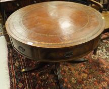 A mahogany drum table with brown leather tooled inset top,