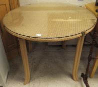 A wicker top circular dining table with faux bamboo legs