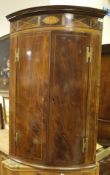 A 19th Century mahogany bow fronted two door wall hanging corner cupboard with decorative inlay and