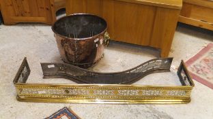 A copper and brass log bin with copper-bodied brass lion masks and drop ring handles,