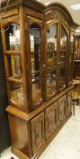 A 20th Century display cabinet with four glazed doors enclosing two glazed shelves on a base of