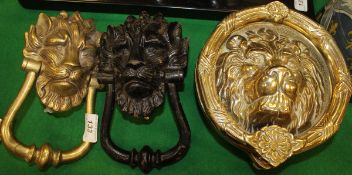 A large brass lion mask door knocker together with two smaller similar