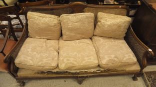 A mahogany three seat sofa with Bergere back and sides and three front cabriole legs to claw and