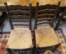 A set of ten oak ladder back rush seated dining chairs and a pine drop-leaf circular table,