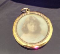 A circa 1900 9 carat gold cased pendant housing two miniatures of young girls CONDITION