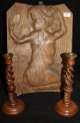 A carved oak panel depicting a kneeling nude admiring her image in a hand mirror and a pair of