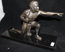 An Art Deco style bronze figure as a huntsman kneeling pointing with spear in his right hand on a