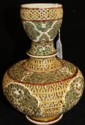 A Zsolnay gourd shaped reticulated vase glazed in gold and greens, raised on a circular foot,