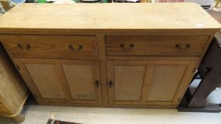 A pine dresser with two drawers over two panelled cupboard doors