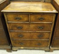 A walnut and mahogany cross banded chest of two short and three long drawers with ogee bracket feet,