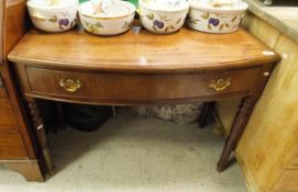 A mahogany bow front hall table with single drawer on turned supports