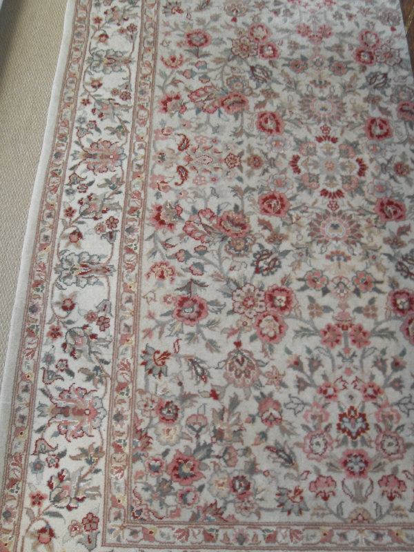 A Persian rug, the central panel set with all-over floral sprays on a cream ground,