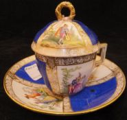 A Meissen miniature chocolate cup and saucer with figural design and simulated breakages within the