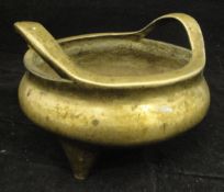 A Chinese bronze censer of squat baluster form with openwork handles, raised on three tapering feet,
