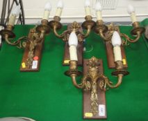 A set of four gilt twin branch wall light fittings