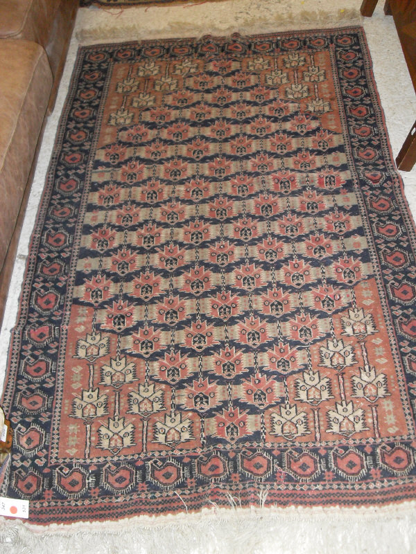 A Turkoman rug, the central panel set with repeating geometric motifs on a blue and red ground,