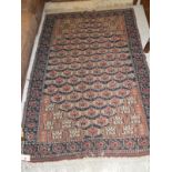 A Turkoman rug, the central panel set with repeating geometric motifs on a blue and red ground,