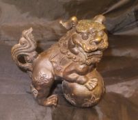 A Chinese bronze figure of a dog of Fo with ball,