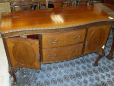 An early 20th Century mahogany serpentine fronted sideboard with two central drawers flanked by
