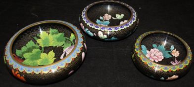 A collection of three Chinese cloisonne black ground floral decorated bowls